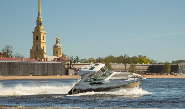 Катер на фоне Петропавловской крепости – аренда катера в СПб от 29000 рублей