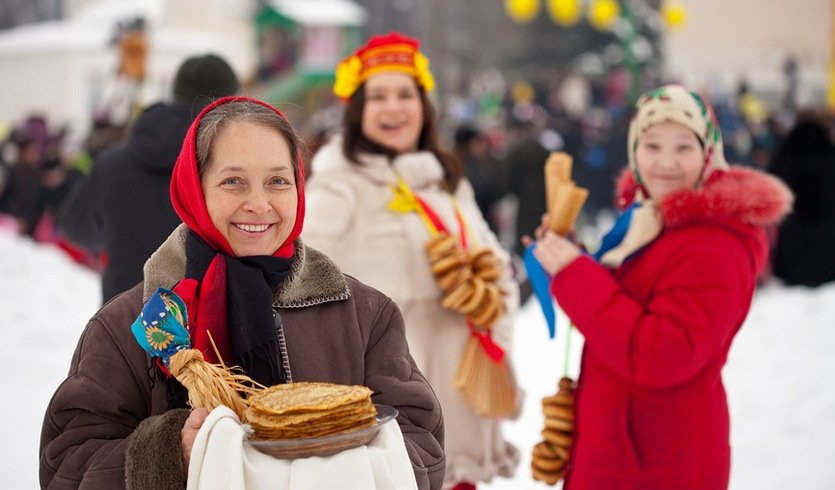 Девушка с блинами во время празднования масленицы – сборные экскурсии для школьников в Санкт-Петербурге