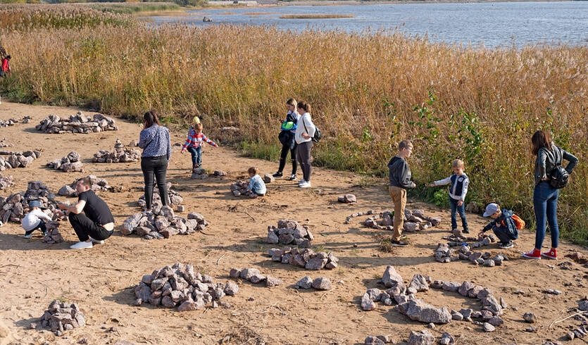 Дети и взрослые на берегу складывают камни – выпускные вечера для 4 класса от 4700 рублей