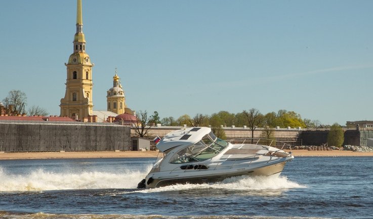 Катер на фоне Петропавловской крепости – аренда катера в СПб от 29000 рублей